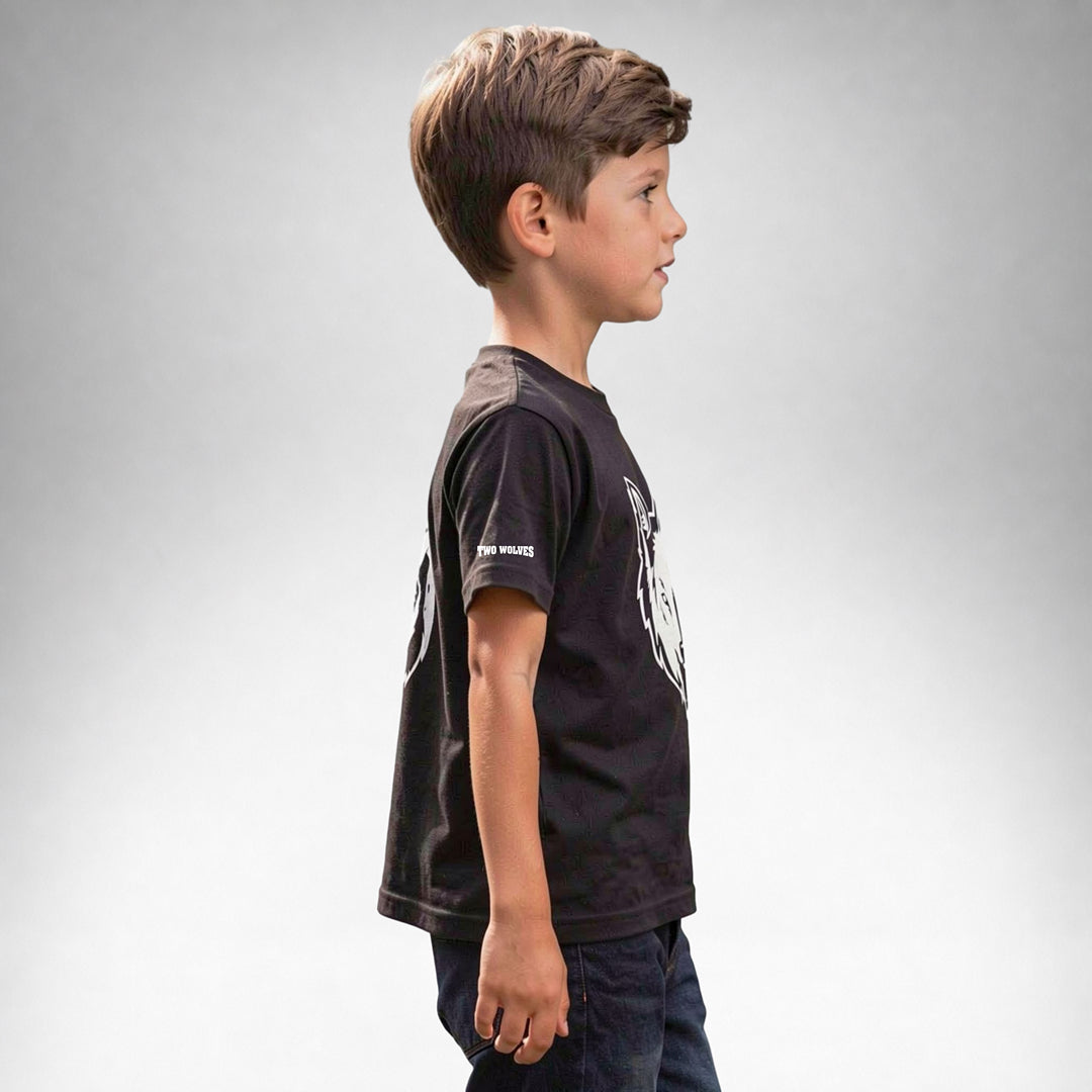 Boy wearing a black Two Wolves Cub Staple T-shirt with a white wolf graphic, facing sideway.