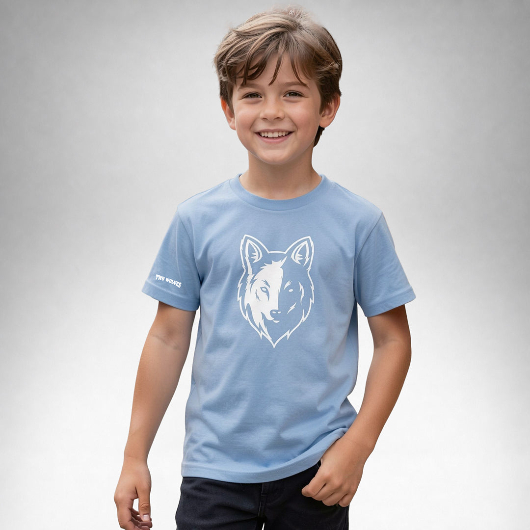 Boy wearing a blue Two Wolves Cub Staple T-shirt with a white wolf graphic on the front.