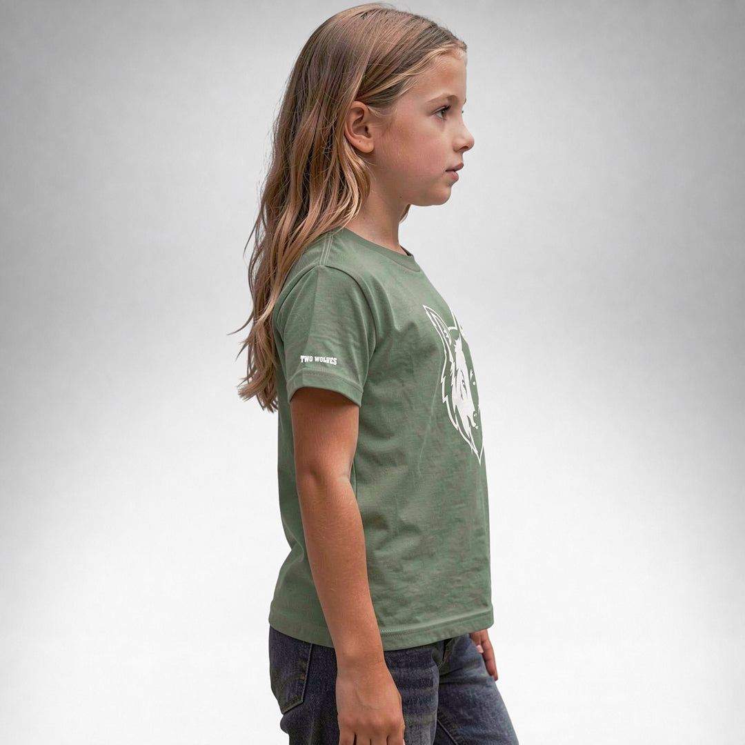 Girl wearing a sage Two Wolves Cub Staple T-shirt with a white wolf graphic, facing sideway.