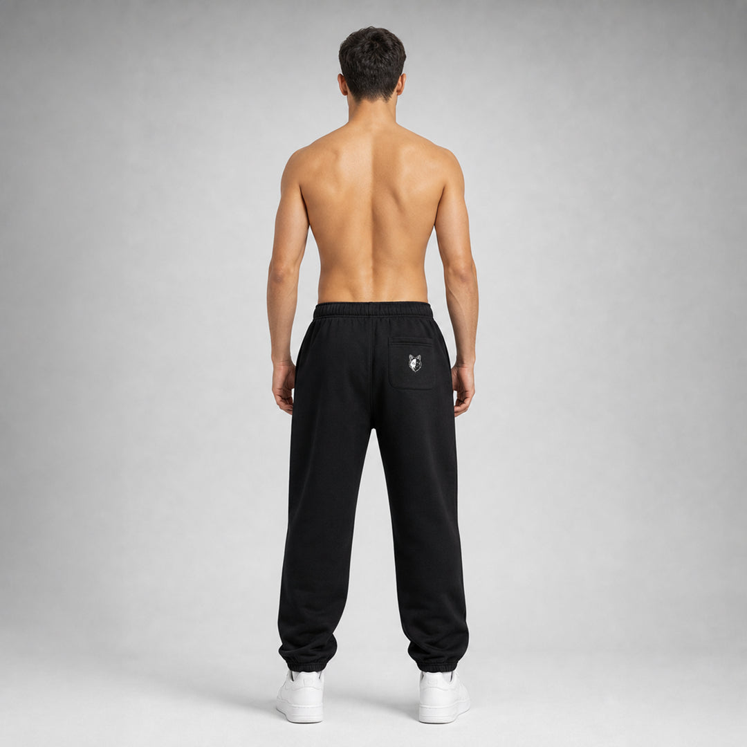 Black Two Wolves track pants, worn by male model facing at the back
