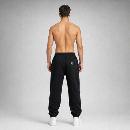 Black Two Wolves track pants, worn by male model facing at the back
